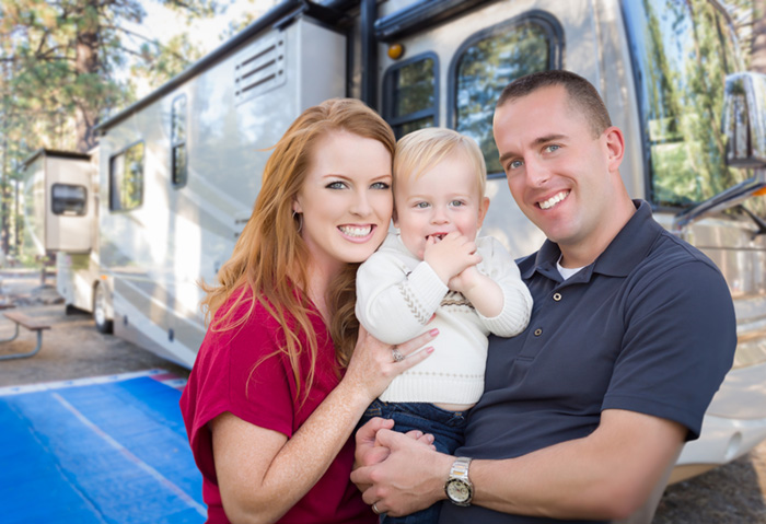 Happy Young Military Family In Front of Their Beautiful RV after RV Inspection.